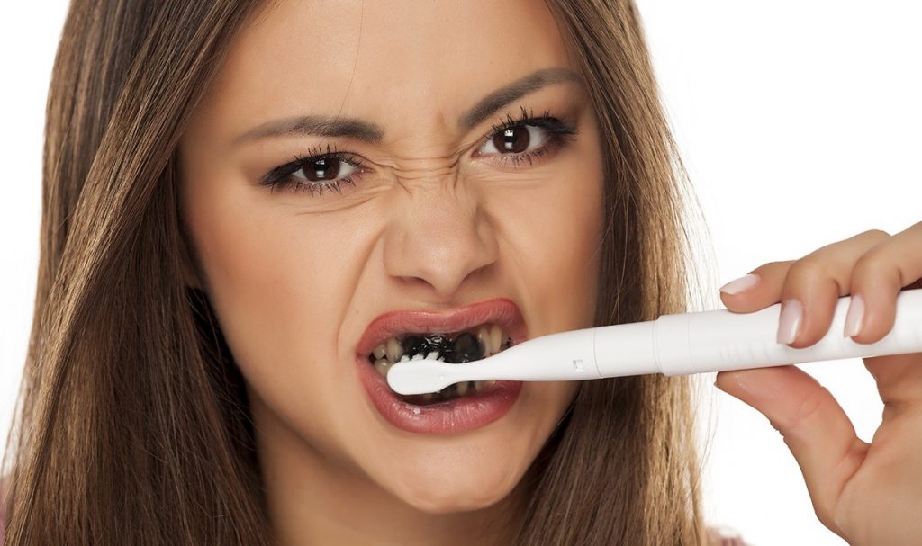 Cleaning teeth with Charcoal toothpaste | Everything You Need To Know About Charcoal Toothpaste | Her Beauty